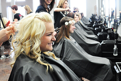 Beauty school student styling a woman's hair